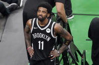 FILE - Brooklyn Nets guard Kyrie Irving looks up at the fans at TD Garden after they defeated the Boston Celtics in Game 4 during an NBA basketball first-round playoff series in Boston, in this Sunday, May 30, 2021. Athletes have been put at center court of arguments over COVID vaccines. The NFL's Aaron Rodgers, the NBA's Kyrie Irving, and tennis's Novak Djokovic, have each become cultural touchstones in the cultural controversy. (AP Photo/Elise Amendola, File)