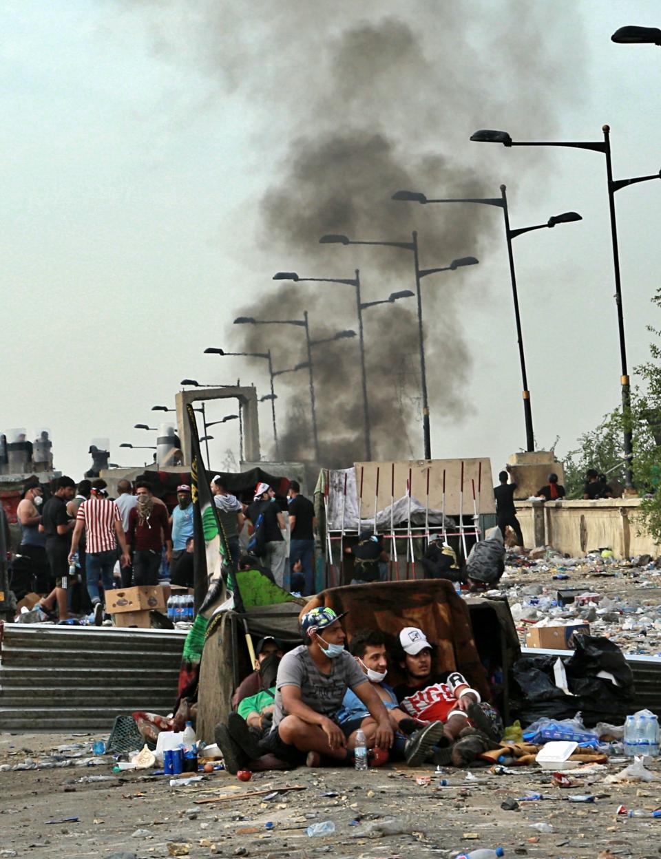 Anti-government protesters set a fire while Iraqi Security forces close the bridge leading to the Green Zone during a demonstration in Tahrir square in Baghdad, Iraq, Sunday, Oct. 27, 2019. Protests have resumed in Iraq after a wave of anti-government protests earlier this month were violently put down. At least 149 people were killed in a week of demonstrations earlier in October. (AP Photo/Hadi Mizban)