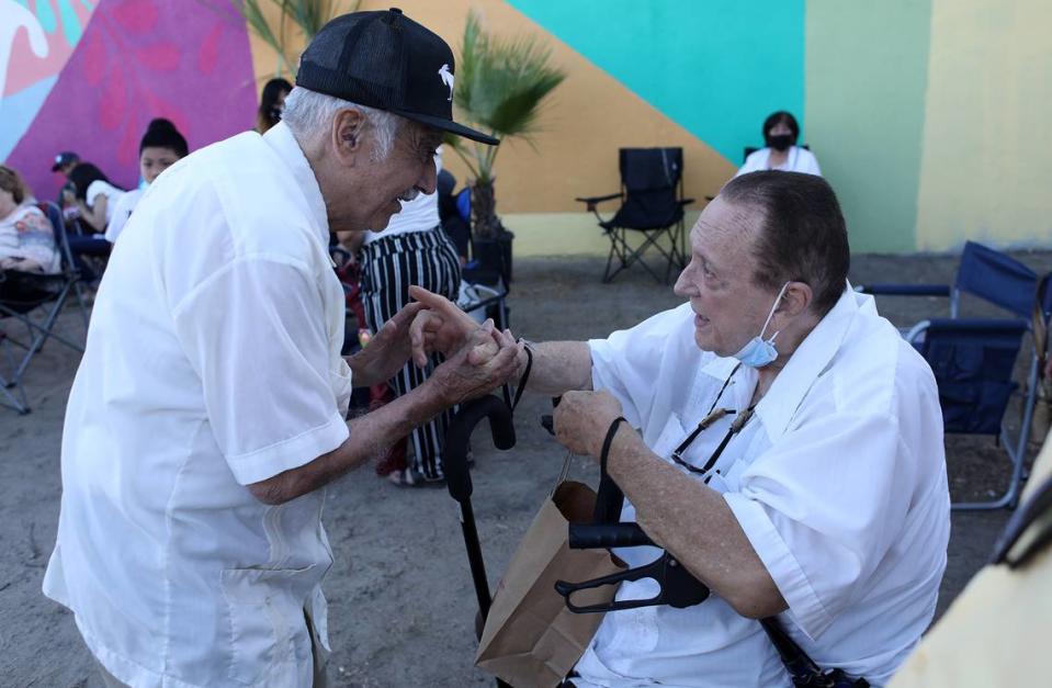 Ernie Palomino chats with former Teatro Campesino member Antonio Bernal during May 2021 unveiling in Del Rey of Bernal’s 1968 mural that was resurrected. Bernal died Sept. 1. Palomino died in October.