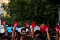 <p>Women raise their hands stained with red paint simulating blood of women killed by men during a thousands-strong march in Santiago de Chile to protest against femicide and gender violence against women. (Mauricio Gomez/NurPhoto via Getty Images)</p>