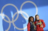 2016 Rio Olympics - Swimming - Victory Ceremony - Women's 100m Freestyle Victory Ceremony - Olympic Aquatics Stadium - Rio de Janeiro, Brazil - 11/08/2016. Joint gold medallists Simone Manuel (USA) of USA and Penelope Oleksiak (CAN) of Canada pose with their medals. REUTERS/Dominic Ebenbichler