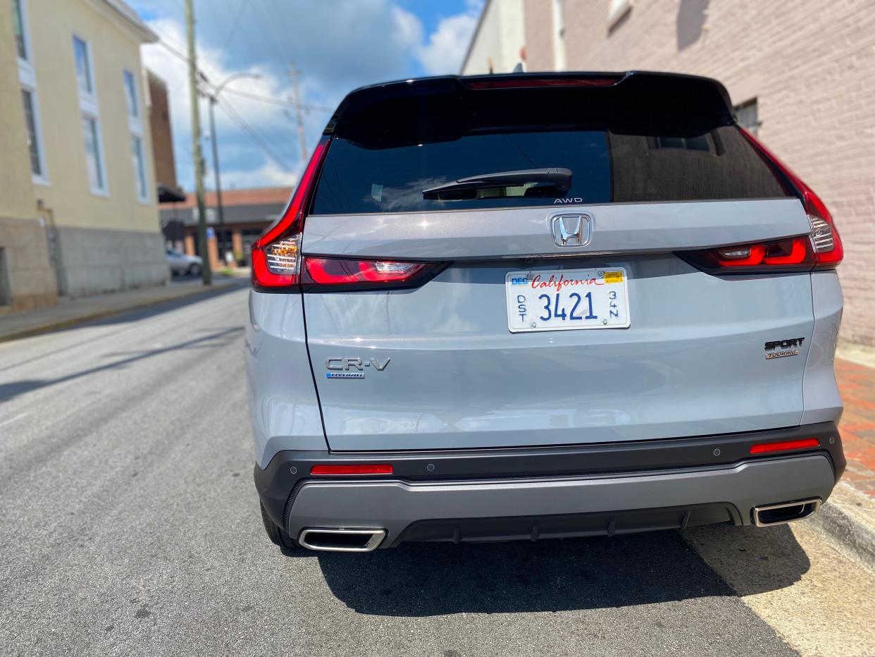 The rear end of a gray 2025 Honda CR-V Hybrid Sport Touring SUV parked on a street.