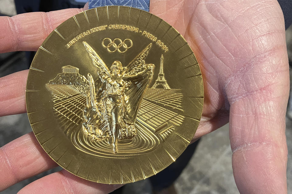 A side of the Paris 2024 Olympic gold medal, featuring an Eiffel Tower at right, is presented Monday, Feb. 5, 2024 in Paris. A hexagonal, polished piece of iron taken from the Eiffel Tower is being embedded in each gold, silver and bronze medal that will be hung around athletes' necks at the July 26-Aug. 11 Paris Games and Paralympics that follow. (AP Photo/John Leicester)