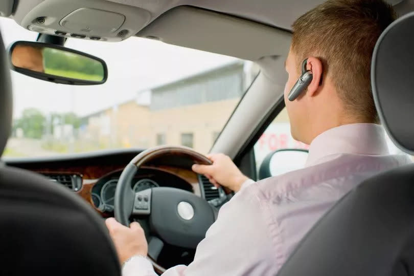 Businessman with headset driving car