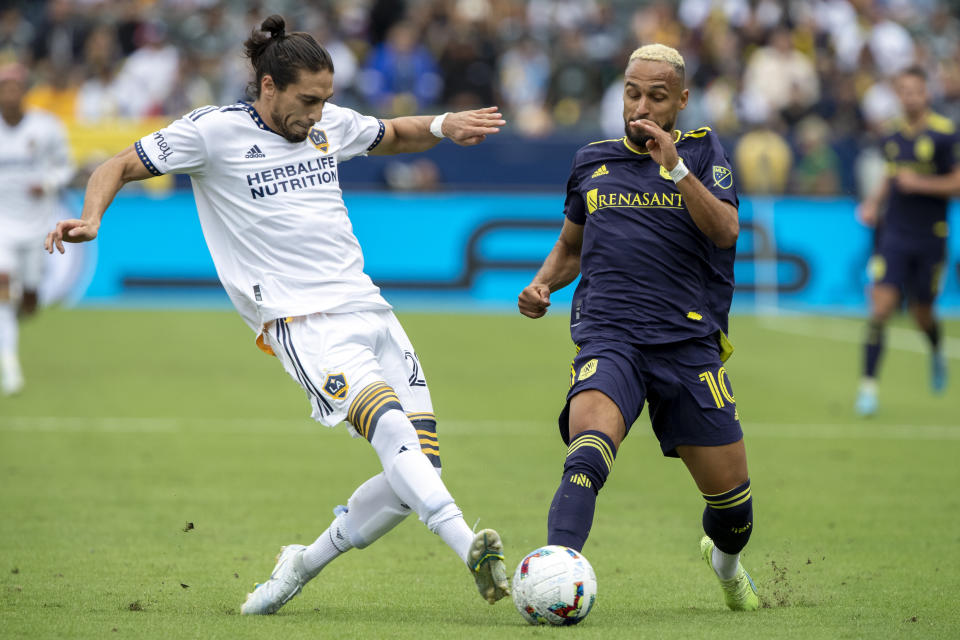 LA Galaxy defender Martin Caceres. left, vies for the ball with Nashville SC midfielder Hany Mukhtar during the first half of an MLS playoff soccer match, in Carson, Calif., Saturday, Oct. 15, 2022. (AP Photo/Alex Gallardo)