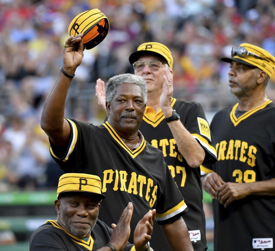 Former Pittsburgh Pirates player Rennie Stennett holds up his hat as he acknowledges the crowd during the 40th anniversary of the 1979 World Series team at PNC Park in Pittsburgh, in this Saturday, July 20, 2019, file photo. In the forground is former Pirates player Manny Sanguillen. Rennie Stennett has died. He was 72. The team, citing information provided by the Stennett family, said Stennett passed away early Tuesday morning, May 18, 2021, following a bout with cancer. (Matt Freed/Pittsburgh Post-Gazette via AP)