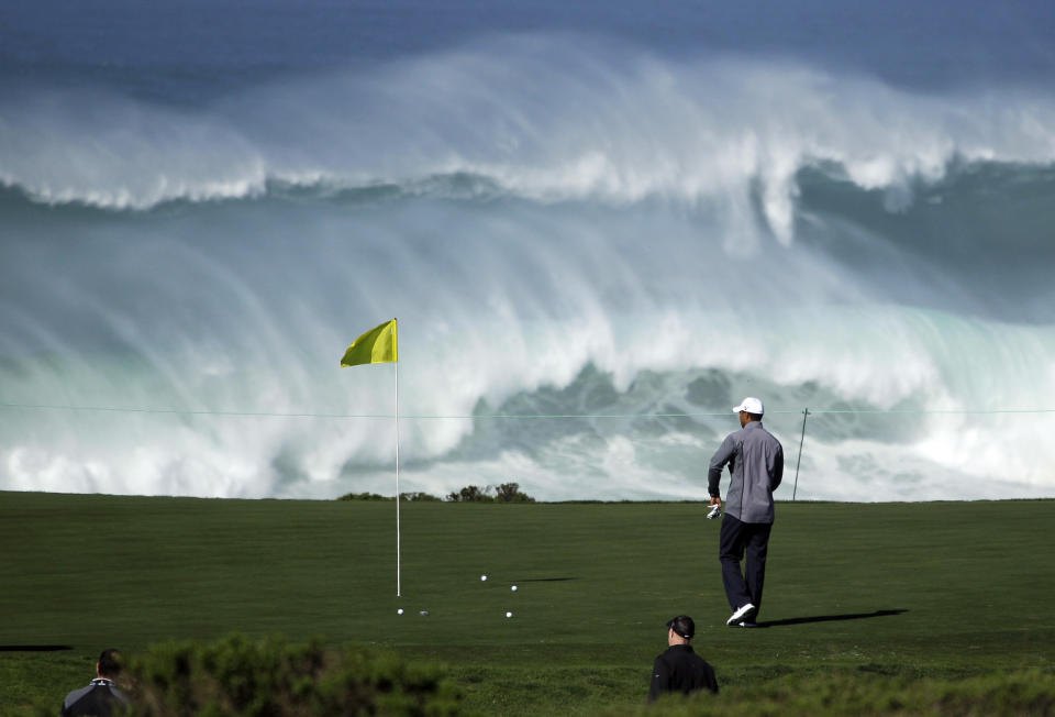 Tiger Woods walks to his ball on the 15th green of the Monterey Peninsula Country Club shore course as waves crash in the background during a practice round at the AT&T Pebble Beach National Pro-Am PGA Tour golf tournament in Pebble Beach, Calif., Wednesday, Feb. 8, 2012. (AP Photo/Eric Risberg)