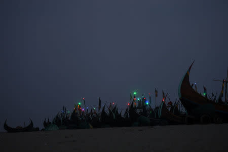 Night lights shine on fishing boats on the shore near Shamlapur Rohingya refugee camp in Cox's Bazaar, Bangladesh, March 21, 2018. REUTERS/Clodagh Kilcoyne