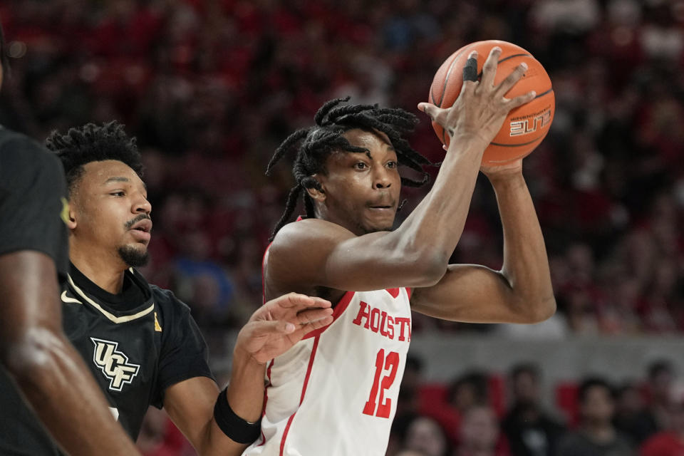 Houston's Tramon Mark (12) looks to pass the ball as Central Florida's Ithiel Horton defends during the first half of an NCAA college basketball game Saturday, Dec. 31, 2022, in Houston. (AP Photo/David J. Phillip)