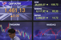 A currency trader stands near screens showing the foreign exchange rates, left, at the foreign exchange dealing room in Seoul, South Korea, Monday, Sept. 23, 2019. Stocks got a downbeat start to the week as investors kept a wary eye on tensions with Iran and on signals from China and the U.S. on prospects for a resolution of their tariffs war. (AP Photo/Lee Jin-man)