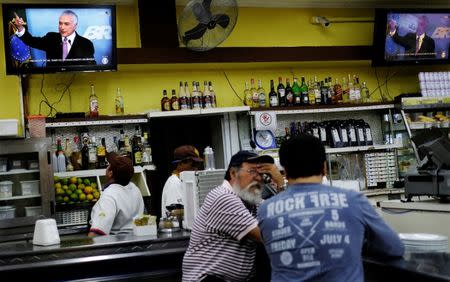 A worker watches television as Brazil's President Michel Temer delivers a speech in Brasilia, at a bar in Sao Paulo, Brazil, June 27, 2017. REUTERS/Nacho Doce