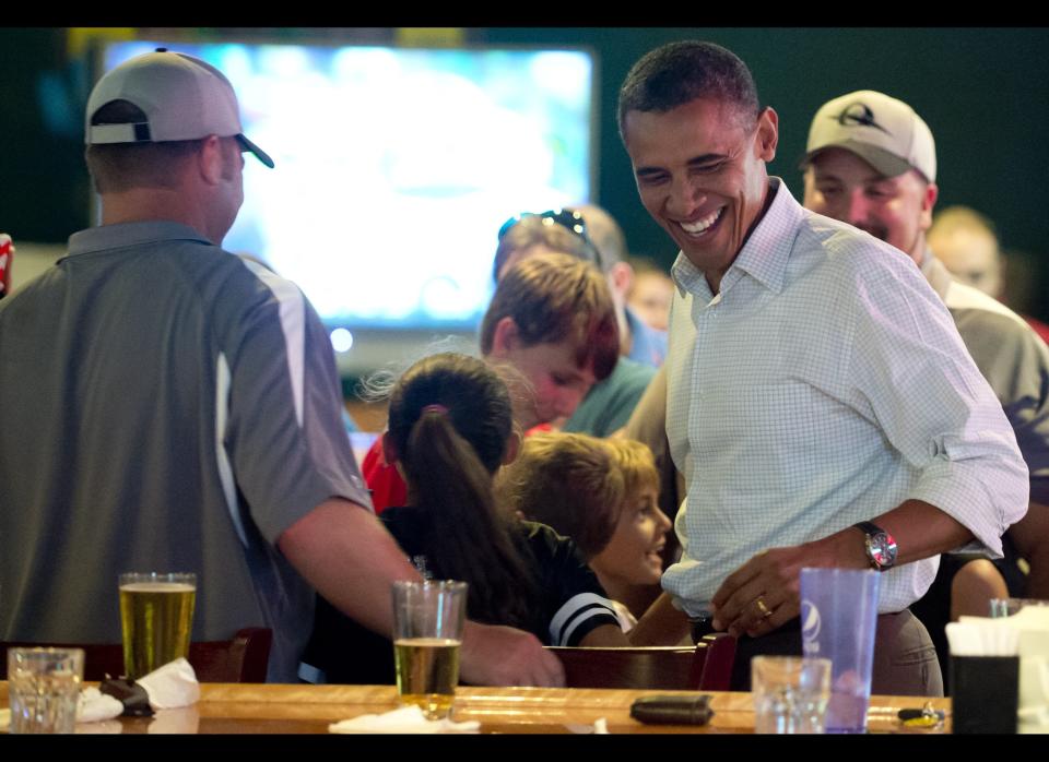Obama picks up a beer during a visit to Gator's Dockside restaurant in Orlando, Florida, September 8, 2012 during the first day of a 2-day bus tour across Florida. AFP PHOTO / Saul LOEB