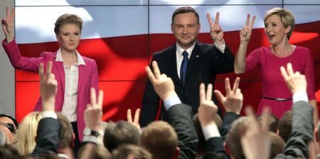 Andrzej Duda, candidate of the conservative opposition Law and Justice (PiS) party shows victory signs with his with wife Agata (R) and daughter Kinga (L) after the announcement of the first exit polls in the first round of the Polish presidential elections, at his election campaign headquarters in Warsaw, Poland May 10, 2015. REUTERS/Slawomir Kaminski/Agencja Gazeta