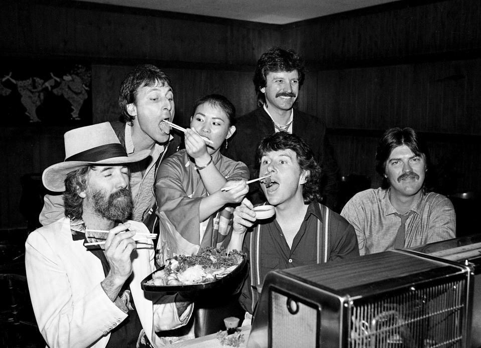 Members of the Nitty Gritty Dirt Band get a helping hand from Shogun Restaurant employee Bo Suk Kim, center, as they celebrate their move to Warner Brothers on April 12, 1984.