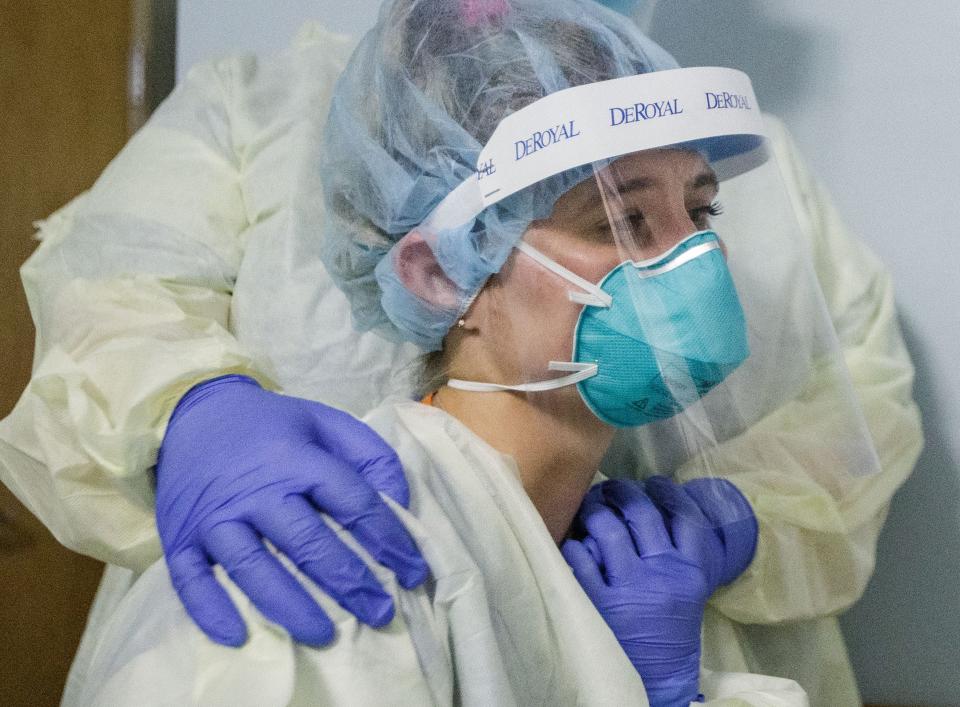 Tallahassee Memorial HealthCare nurse Charlee Mehr sits on the bed next to her patient to comfort him as he dies from COVID-19 Monday, Aug. 23, 2021. Mehr works in the yellow level COVID unit at TMH.