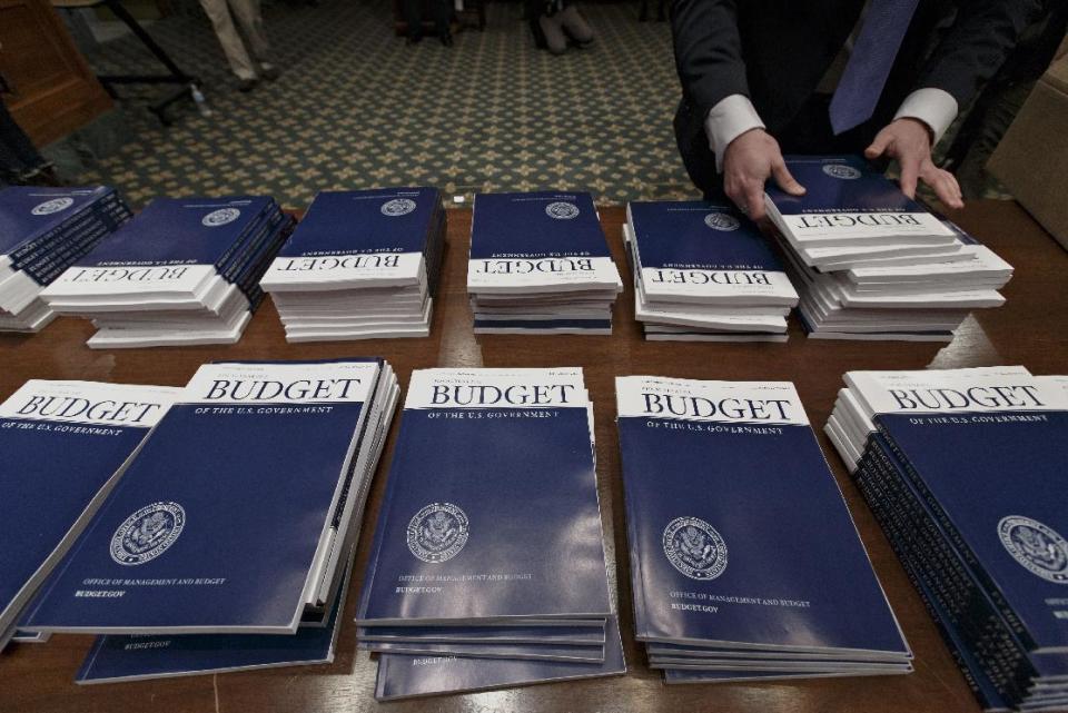 Copies of President Barack Obama’s proposed fiscal 2015 budget are set out for distribution by Senate Budget Committee Clerk Adam Kamp, on Capitol Hill in Washington, Tuesday, March 4, 2014. President Barack Obama is unwrapping a nearly $4 trillion budget that gives Democrats an election-year playbook for fortifying the economy and bolstering Americans' incomes. It also underscores how pressure has faded to launch bold, new attacks on federal deficits. (AP Photo/J. Scott Applewhite)