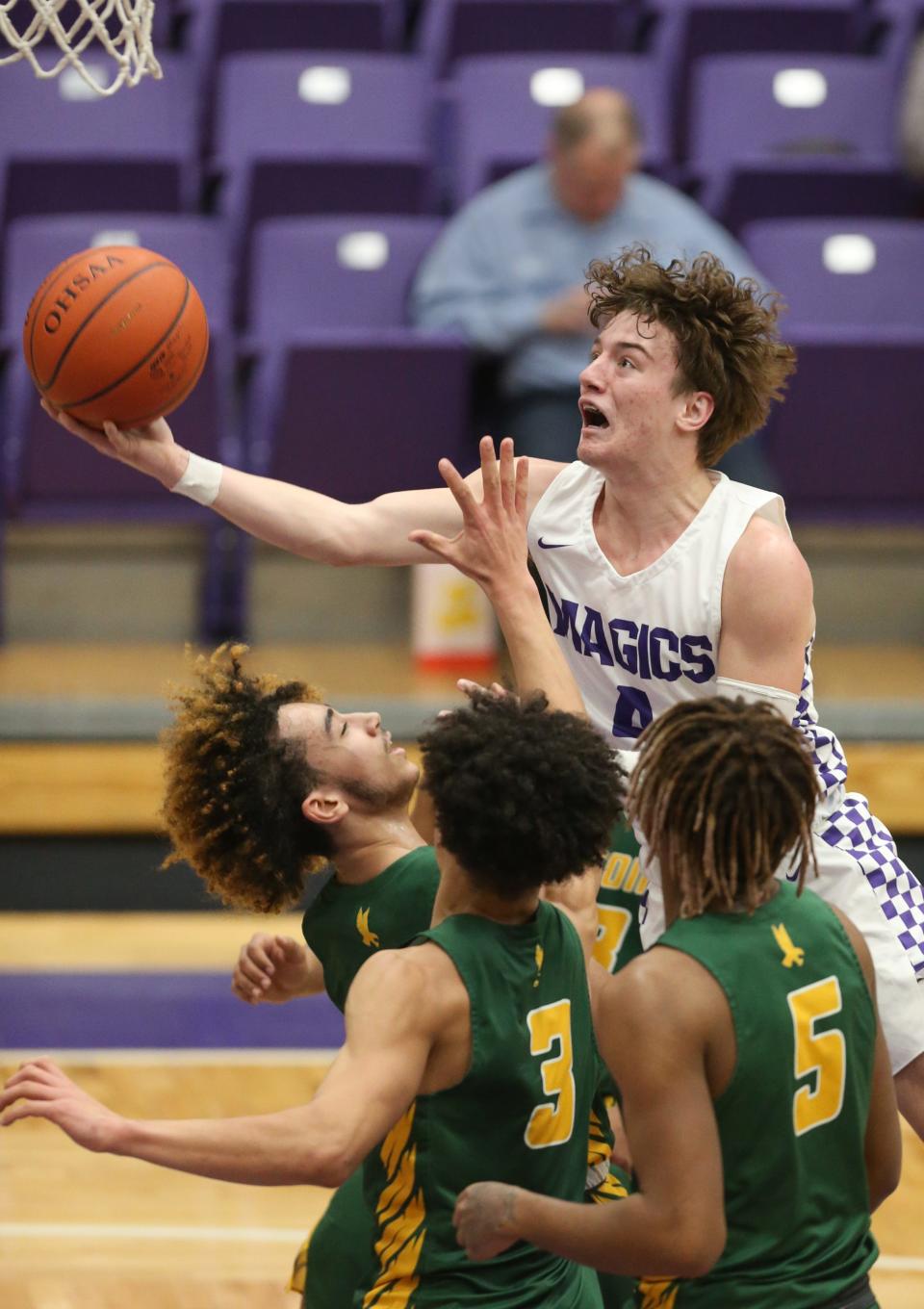 Barberton's Kaige Lowe drives to the basket over three Firestone defenders during the second quarter of the Falcons' 50-48 win Wednesday night. [Phil Masturzo/Beacon Journal]