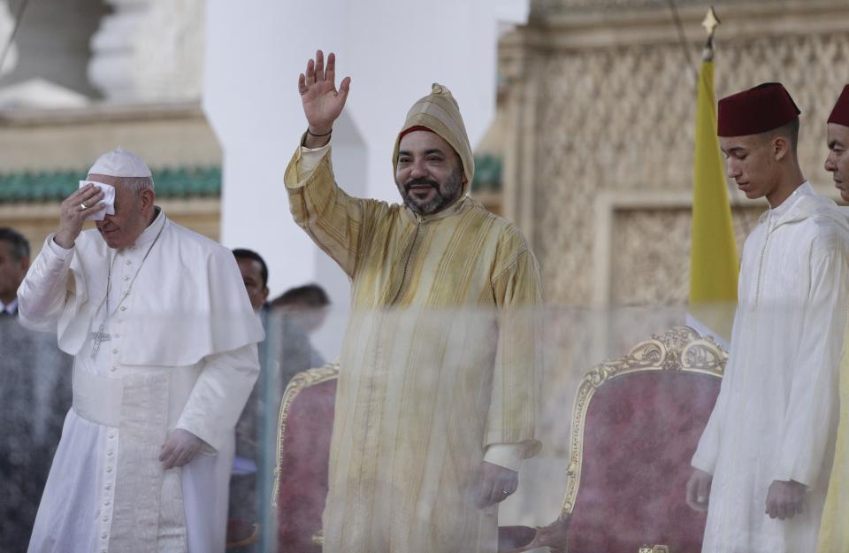 Moroccan King Mohammed VI waves as Pope Francis wipes his forehead, in Rabat, Morocco, Saturday, March 30, 2019. Francis's weekend trip to Morocco aims to highlight the North African nation's tradition of Christian-Muslim ties while also letting him show solidarity with migrants at Europe's door and tend to a tiny Catholic flock on the peripheries. (AP Photo/Gregorio Borgia)