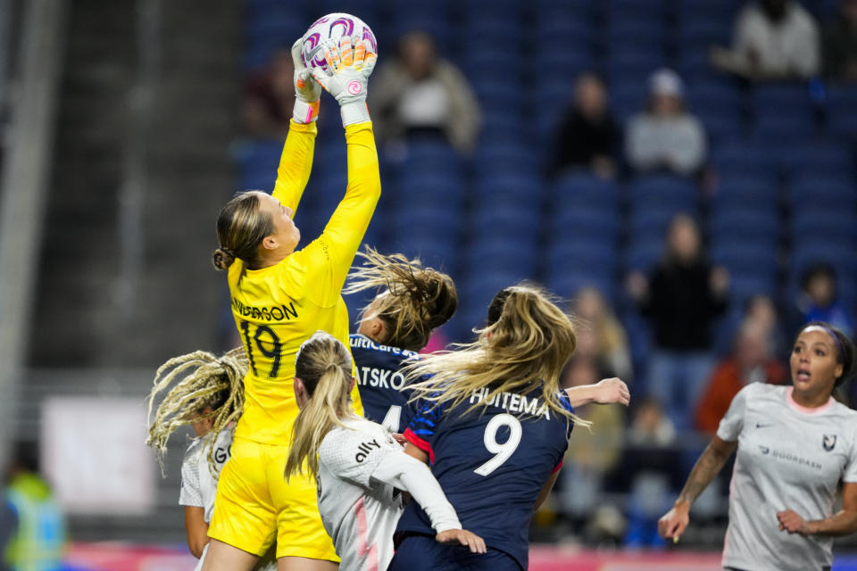 Angel City FC goalkeeper Angelina Anderson (19) goes up for a save against OL Reign forwards Veronica Latsko, back center, and Jordyn Huitema (9) during the first half of an NWSL quarterfinal playoff soccer match Friday, Oct. 20, 2023, in Seattle. (AP Photo/Lindsey Wasson)