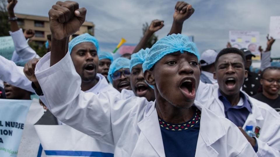 Kenyan doctors chant outside the health ministry headquarters protesting with placards to demand better pay and working conditions in the capital, Nairobi on April 9, 2024