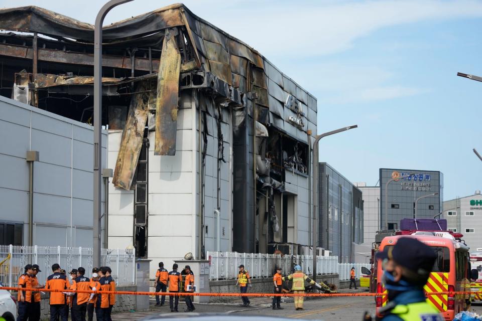 Firefighters and a police officer work outside of the site of a burnt battery manufacturing factory in Hwaseong, South Korea (Copyright 2024 The Associated Press. All rights reserved)