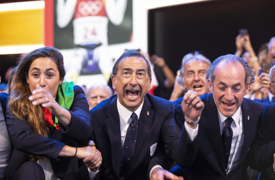 Mayor of Milan Giuseppe Sala, center, and members of Milan-Cortina delegation celebrate after winning the bid to host the 2026 Winter Olympic Games, during the first day of the 134th Session of the International Olympic Committee (IOC), at the SwissTech Convention Centre, in Lausanne, Switzerland, Monday, June 24, 2019. Italy will host the 2026 Olympics in Milan and Cortina d'Ampezzo, taking the Winter Games to the Alpine country for the second time in 20 years. (Xu Jinquan/Pool via AP)