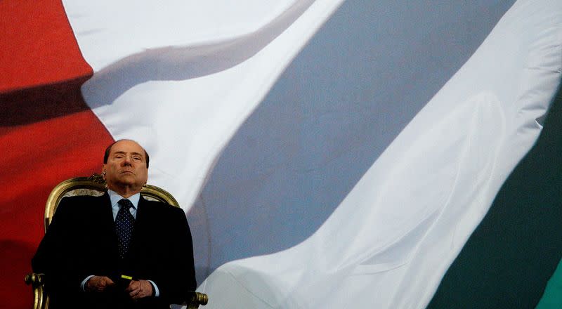 FILE PHOTO: Italy's Prime Minister Berlusconi attends a carousel performed by Italian Carabinieri Cavalry and Barbary Cavalry in Rome