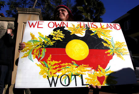 FILE PHOTO - An Aboriginal protester holds a placard as she stands outside the Australian Prime Minister's office in Sydney, Australia, July 6, 2015. REUTERS/David Gray/File photo