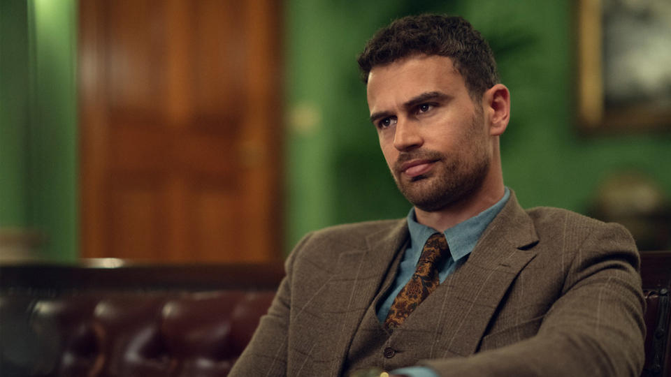 Theo James sits on a chair in the Gentlemen