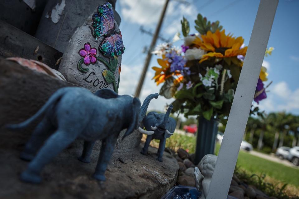 Trinkets and other memorial tokens, along with flowers and a cross, decorate the memorial for Kristina Spadavecchia.