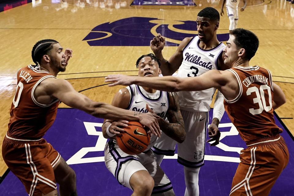 Texas forwards Timmy Allen, left, and Brock Cunningham try to steal the ball from Kansas State forward Keyontae Johnson during the second half of the Longhorns' 69-66 win over the No. 7 Wildcats. No. 10 Texas continues to lead the Big 12.