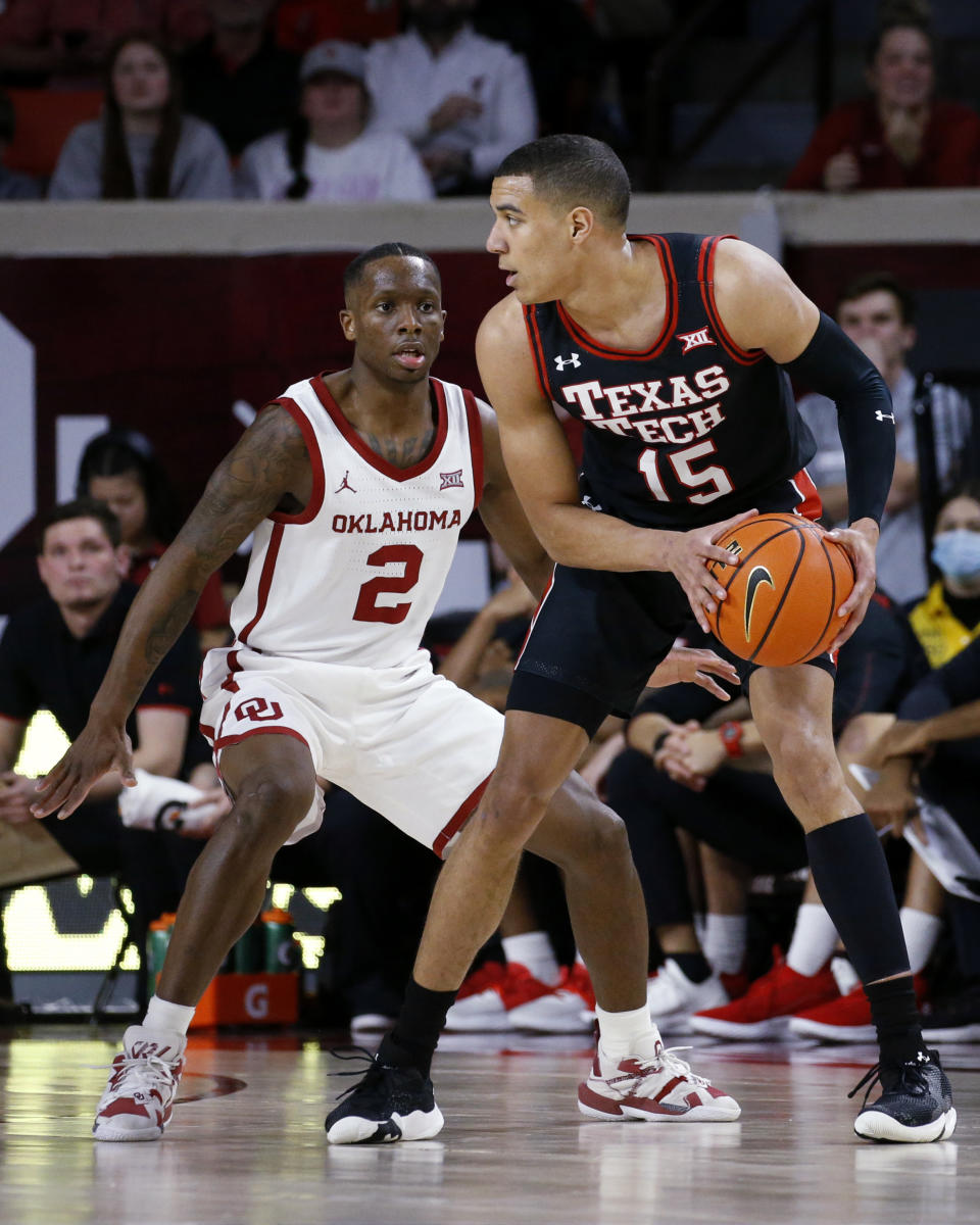 Texas Tech guard Kevin McCullar (15) is defended by Oklahoma guard Umoja Gibson (2) during the second half of an NCAA college basketball game Wednesday, Feb. 9, 2022, in Norman, Okla. (AP Photo/Garett Fisbeck)