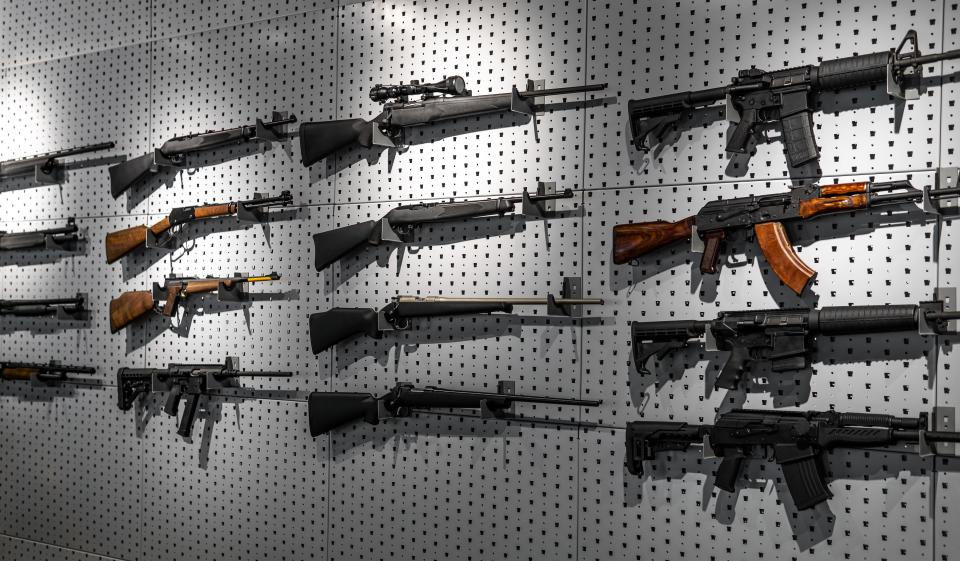 Various firearms hang on special mounts on the wall.