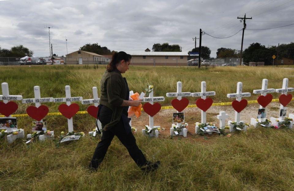 Jessica Mires leaves flowers on crosses for the victims of the mass shooting that killed 26 people at the First Baptist Church in Sutherland Springs, Texas, on Nov. 9, 2017.  / Credit: AFP/Getty