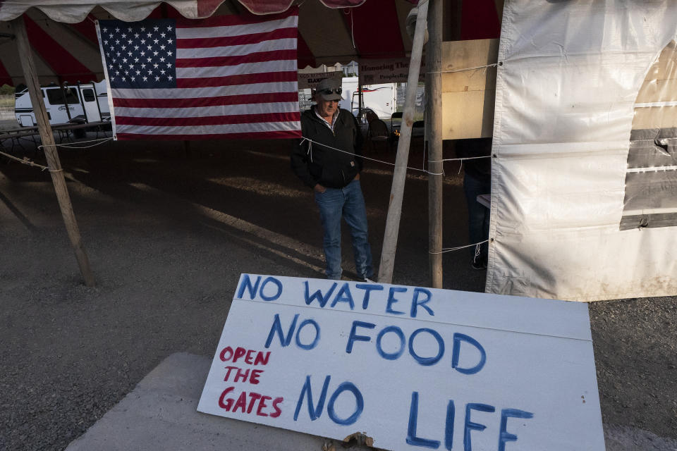 Danny Nielsen walks through a tent on property he purchased next to the head gates of the Klamath River, on Wednesday, June 9, 2021, in Klamath Falls, Ore. Nielsen, who owns 43 acres in the Klamath Project, is among those who have threatened to forcibly open the head gates of the Upper Klamath Lake if the U.S. Bureau of Reclamation does not release water for downstream users. (AP Photo/Nathan Howard)