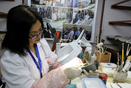 A Japanese archeologist studies a fragment of the second Khufu boat, which will be restored following its discovery near the Great Pyramids in Giza, Egypt, March 29, 2017. REUTERS/Mohamed Abd El Ghany