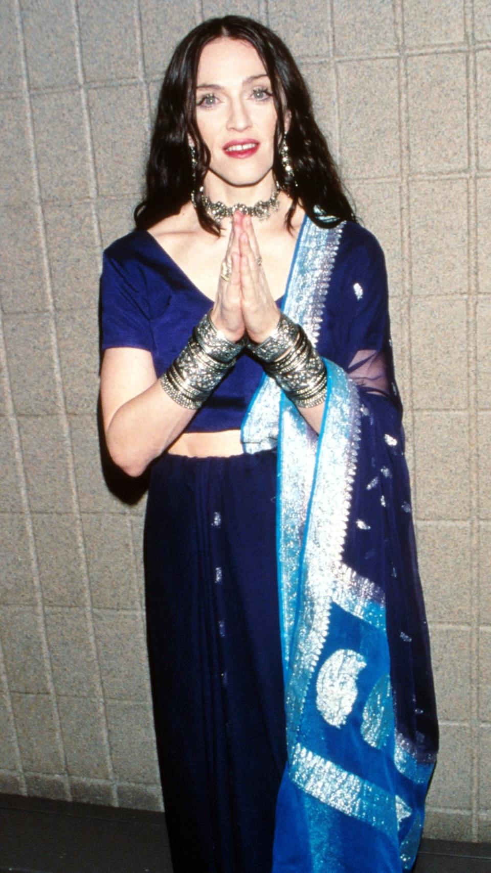 <p> At the same event she donned the corseted yellow gown, Madonna changed into this traditional sari get-up backstage. From the spiritual attire to the loose black curls, Madonna was certainly making a point that she had begun a new era - one more reflective, mature and removed from her wilder past. </p>