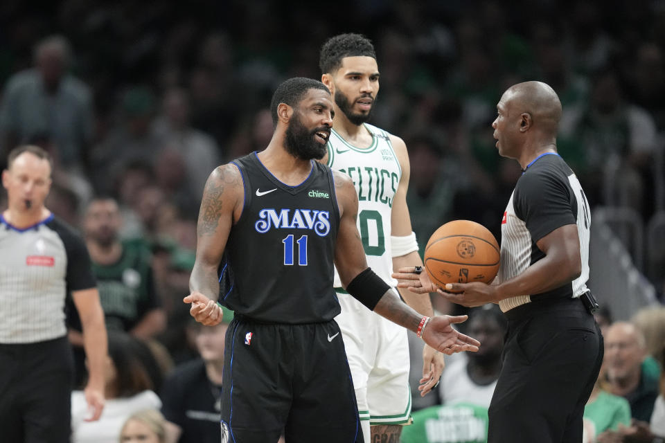 Dallas Mavericks guard Kyrie Irving (11) questions referee Courtney Kirkland after he was called for a foul, as Boston Celtics forward Jayson Tatum (0) listens during the second half of Game 1 of basketball's NBA Finals on Thursday, June 6, 2024, in Boston. (AP Photo/Charles Krupa)