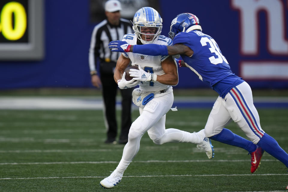 Detroit Lions wide receiver Amon-Ra St. Brown (14) runs the ball against New York Giants cornerback Darnay Holmes (30) during the second half of an NFL football game, Sunday, Nov. 20, 2022, in East Rutherford, N.J. (AP Photo/Seth Wenig)