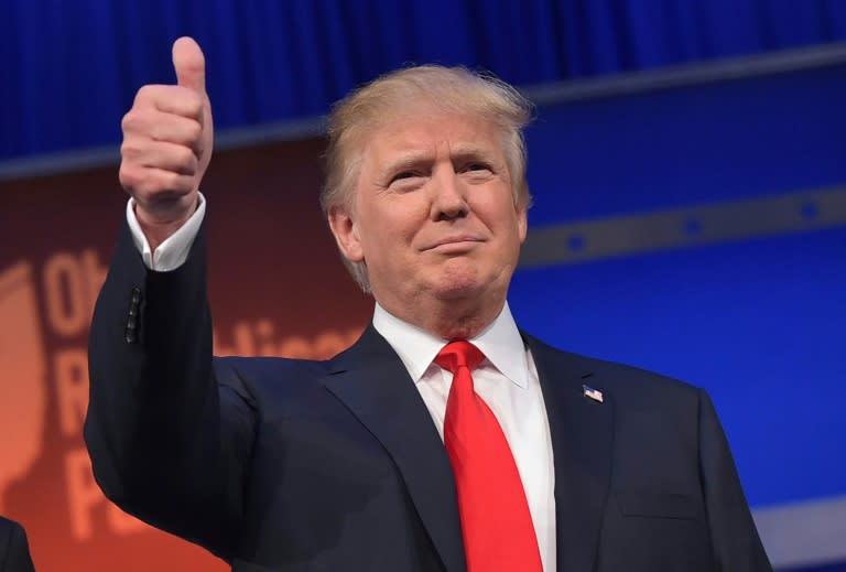 Real estate tycoon Donald Trump flashes the thumbs-up as he arrives on stage for the start of a Republican presidential debate at the Quicken Loans Arena in Cleveland, Ohio, August 6, 2015