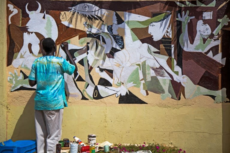 South Sudanese artist Adija Ajuil works on a new mural inspired by "Guernica"