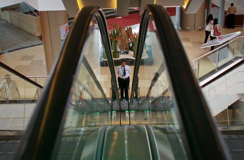 A security guard stands between escalators inside a shopping mall in Mumbai