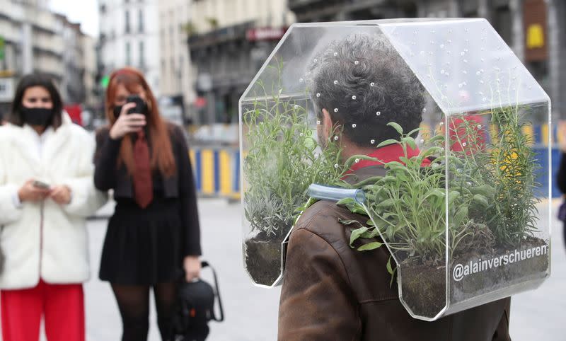 Belgian artist Alain Verschueren wears his "Portable Oasis" while performing in Brussels