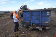 Republic Services operator George Maya removes painted woods from a mountain of yard, garden and landscape waste at the Otay Landfill in Chula Vista, Calif., on Friday, Jan. 26, 2024. Two years after California launched an effort to keep organic waste out of landfills, the state is so far behind on getting food recycling programs up and running that it's widely accepted next year's ambitious waste-reduction targets won't be met. (AP Photo/Damian Dovarganes)