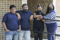 In this Sept. 26, 2021, photo Royal Smart, left, poses with his siblings and mother in a Chicago park. Smart still has nightmares about being handcuffed for nearly 30 minutes two years ago, alongside his mother and other adults. Neither he nor anyone else was arrested when police wielding a warrant came looking for illegal weapons and found none in the family's home on Chicago's South Side. From left are Royal, Roy and Royalty, and their mother, Domonique Wilson. (AP Photo/Teresa Crawford)