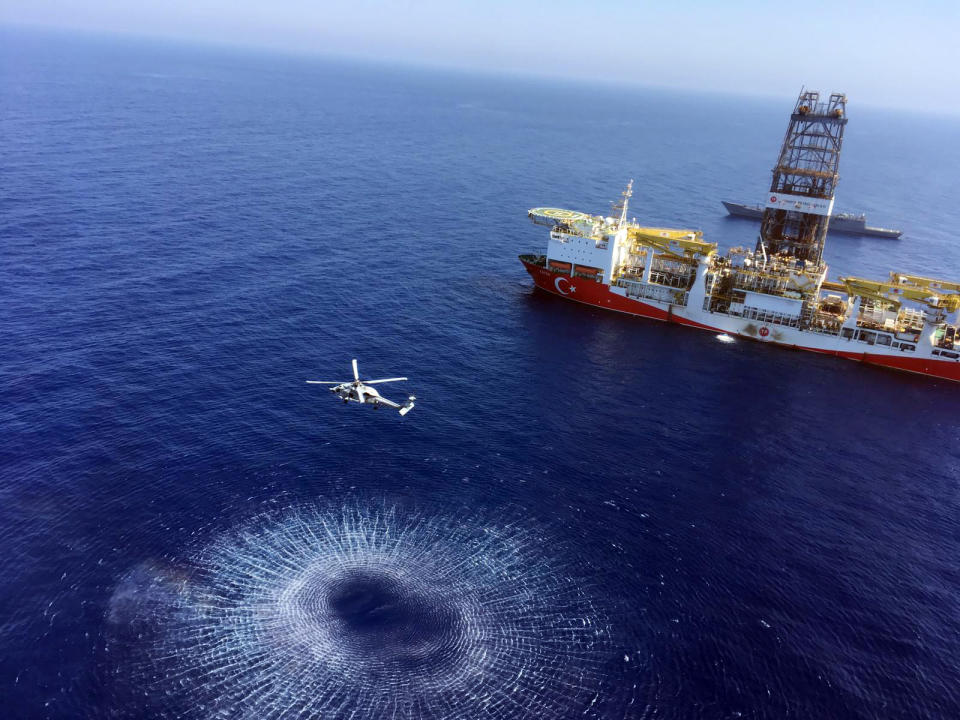 In this Tuesday, July 9, 2019 photo, a helicopter flies near Turkey's drilling ship, 'Fatih' dispatched towards the eastern Mediterranean, near Cyprus. Turkish officials say the drillships Fatih and Yavuz will drill for gas, which has prompted protests from Cyprus.(Turkish Defence Ministry via AP, Pool)