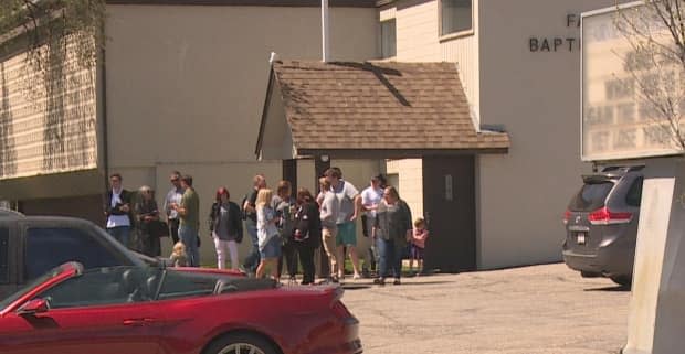 Congregants are seen gathered outside of the Fairview Baptist Church in southeast Calgary on Sunday, shortly before the arrest of Pastor Tim Stephens.