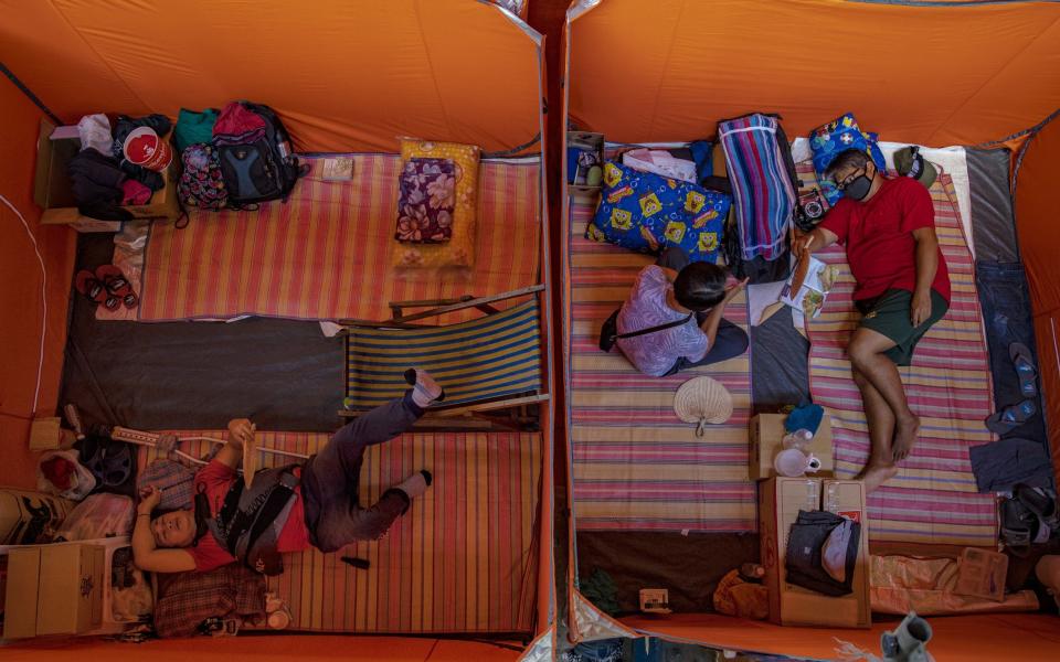 Homeless people, who are unable to feed themselves and unable to work because of government lockdown measures, occupy tents as they observe social distancing in a gymnasium in Manila - Getty