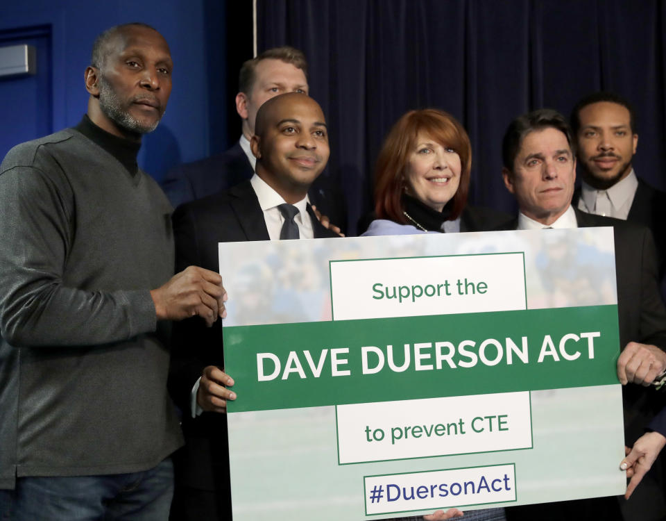 Tregg Duerson, and Carol Sente are surrounded by supporters of a bill banning football for young Illinois children. (AP)