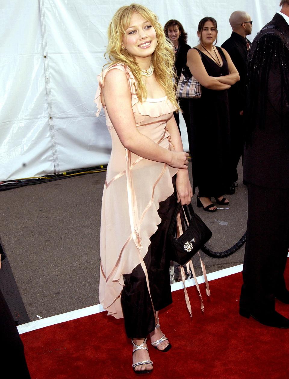 An asymmetrical blouse paired with black pants was Hilary's choice for the American Music Awards in 2003. 